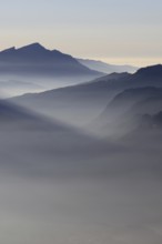 Mountain silhouettes... Alpine peaks and mountain ranges in the Bavarian Alps, light fog rises from