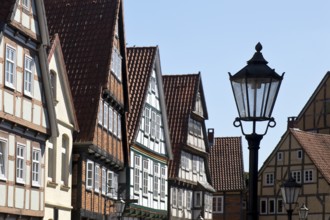 Street with half-timbered houses and historic street lamp in the old town centre, Celle, Lower