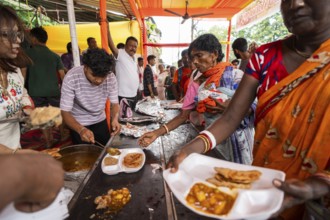 Devotees throng to have food as they arrives to visit Kamakhya Temple during Ambubachi Mela, in