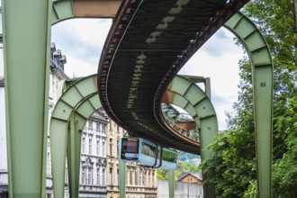 The Wuppertal suspension railway runs through Vohwinkel in front of buildings from the Wilhelminian