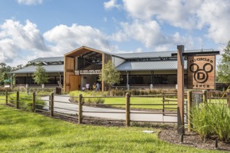 Family entering the Tri-Circle-D Ranch horse stables in the Fort Wilderness Campground and Resort