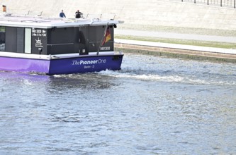 The media ship The Pionieer One sails on the Spree near the Kapelleufer