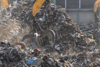 Hydraulic crane lifts scrap metal at the scrap yard