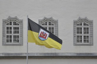 Flag with town coat of arms and three windows with metal lattice, decorations, Old Town Hall,