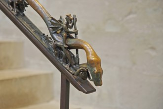 Handrail with sculpture and decorations, devil with wings riding on a snake, snake figure, snake