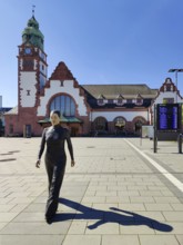 Realistic artwork entitled Walking Woman by Sean Henry on the square in front of the railway