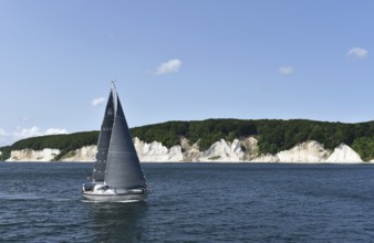 Sailing boat passes the chalk coast of Rügen, Mecklenburg-Vorpommern, Germany