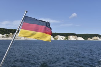 German flag in front of the chalk cliffs on Rügen, Mecklenburg-Western Pomerania, Germany