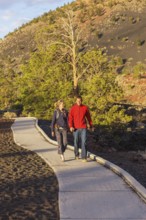 Couple walking on pathway, Sunset Crater Volcano National Monument, Flagstaff, Arizona, USA