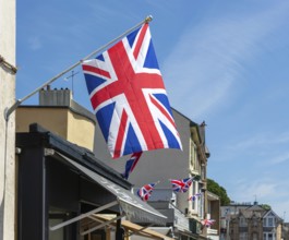 Union Jack flags on shops in street of historic buildings, The Strand, Dawlish, south Devon,