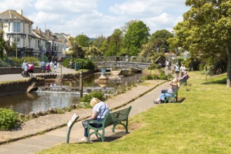 Dawlish Water river flowing through park gardens in town centre, Dawlish, south Devon, England, UK