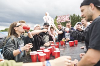 Festival visitors play a drinking game on a campsite at the Rock am Ring Festival on Saturday,