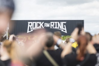 Festival visitors in front of a container with Rock am Ring logo at the Rock am Ring Festival on