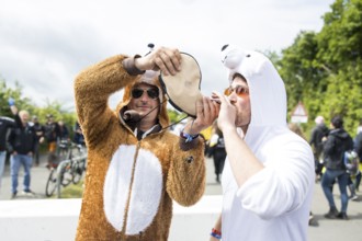 Two festival visitors in animal costumes drink from a horn at the Rock am Ring festival on Friday,