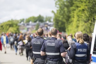 Police officers watch festival visitors on their way to the main entrance at the Rock am Ring