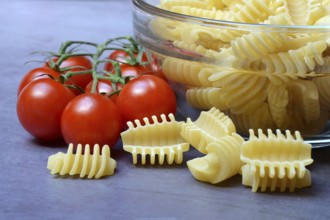 Italian pasta in glass bowl and cooking spoon, Radiatori variety