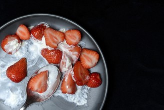Sliced strawberries and whipped cream on a plate, dessert