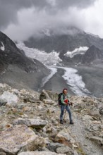 Mountaineer descending Col de Riedmatten, view of glacier Glacier de Cheilon and mountain peak Mont