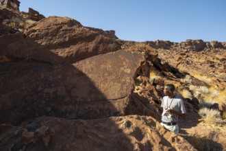 Tourist guide explains the details of the rock engravings at Twyfelfontein, Twyfelfontein, Kunene,