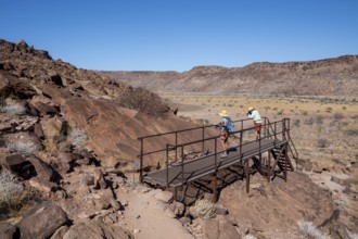 Tourists on a platform at the rock engravings of Twyfelfontein, Twyfelfontein, Kunene, Namibia