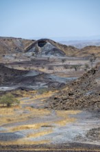 Dry landscape with yellow grass and black volcanic hills, Burnt Mountain, Damaraland, Kunene,