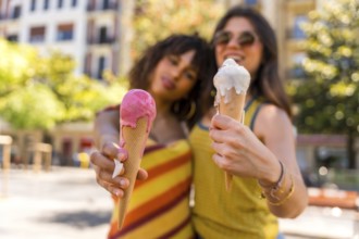 Two female friends savoring delicious ice cream cones on a sunny summer day, enjoying each other's