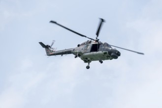 Naval helicopter flies in front of a clear sky, majestic and technical, Prerow,