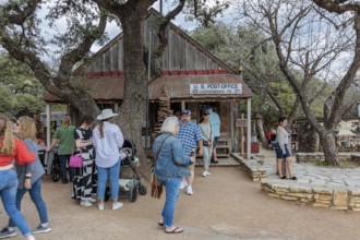 Tourists mingle outside the US post office in Luckenbach, Texas, USA