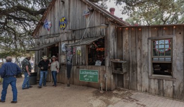 Tourists drinking beer at an open-air bar in Luckenbach, Texas, USA