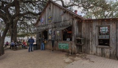 Tourists buying beer at an open-air bar in Luckenbach, Texas, USA