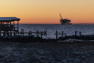 Fossil fuel drilling rig on the Gulf of Mexico horizon at Fort Morgan, Alabama, USA