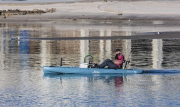 Man in Hobie kayak heads into the Gulf of Mexico for fishing at Gulfport, Mississippi, USA
