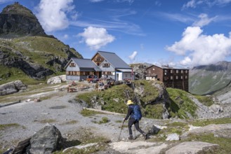 Mountaineer in front of mountain hut Cabane de Prafleuri in mountain landscape, Valais, Western