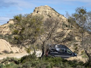 Camper van, gravel road Ruta Jubierre, desert, rock formations, Desierto de los Monegros, Spain
