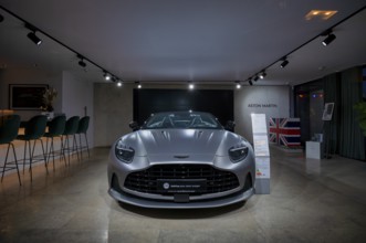 View through shop window to showroom, interior shot, sales exhibition of the car brand Aston