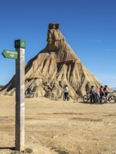 Group of cyclists, Castildetierra rock formation, semi-desert, Bardena Blanca area, Bardenas Reales
