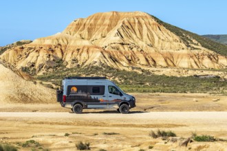 Camper van, colorful rock formation, semi-desert, Bardena Blanca area, Bardenas Reales Nature Park,