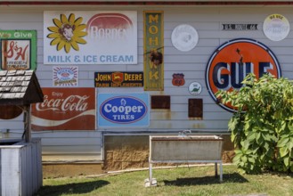 Antique metal advertising signs used for decoration on the side of a building near Counce,