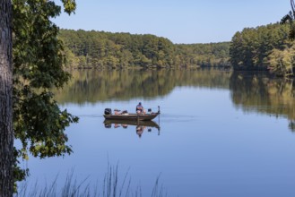 Man fishing in small boat on Pin Oak Lake in Natchez Trace State Park near Wildersville, Tennessee