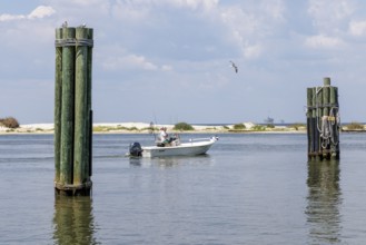Two men on a fishing boat in Mobile Bay along the coast of Dauphin Island in Alabama