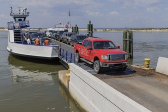 Vehicles driving off the Mobile Bay Ferry at Dauphin Island, Alabama