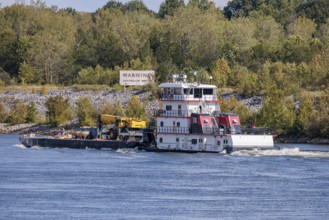 Tennessee Valley Authority tug boat Freedom pushing a barge with construction equipment upstream on