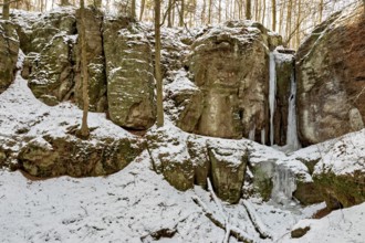 Snow-covered rocks with frozen waterfalls in a forest, The Dragon Gorge near Eisenach in Thuringia