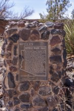 Plaque on stone historical marker provides information on the historic wagon road through Arizona