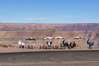 Tourists waiting for bus transportation at covered picnic tables at Guano Point in Grand Canyon