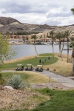 Senior golfers teeing off while playing on a golf course along the shoreline of Las Vegas Wash at