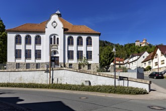 A white building with red tiled roofs in a small, quiet village under a blue sky, the town of