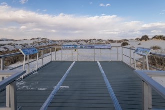 Signage informs visitors about dunes and wildlife along the Interdune Boardwalk over the gypsum