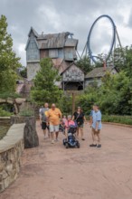 Family of park guests walking past the Mystery Mine roller coaster ride at the Dollywood amusement