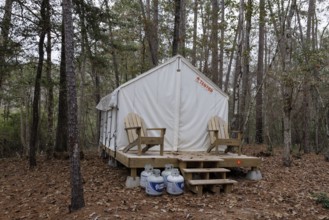 Propane tanks outside a Tentrr glamping tent on a raised platform with a wooden porch at Clarko